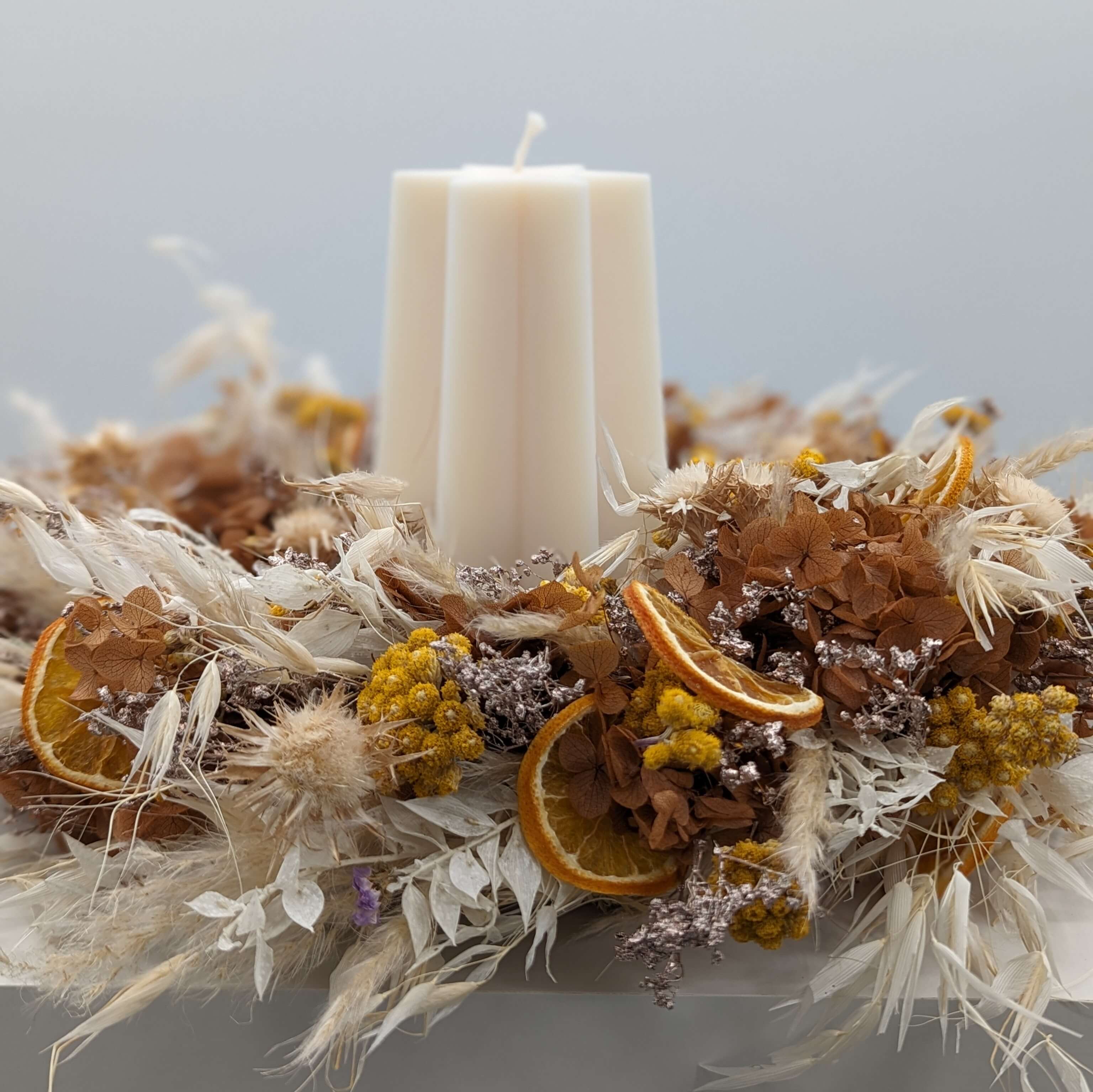 Elegant holiday wreath with four pink candles, adorned with greenery and festive decorations. Perfect for seasonal decor.