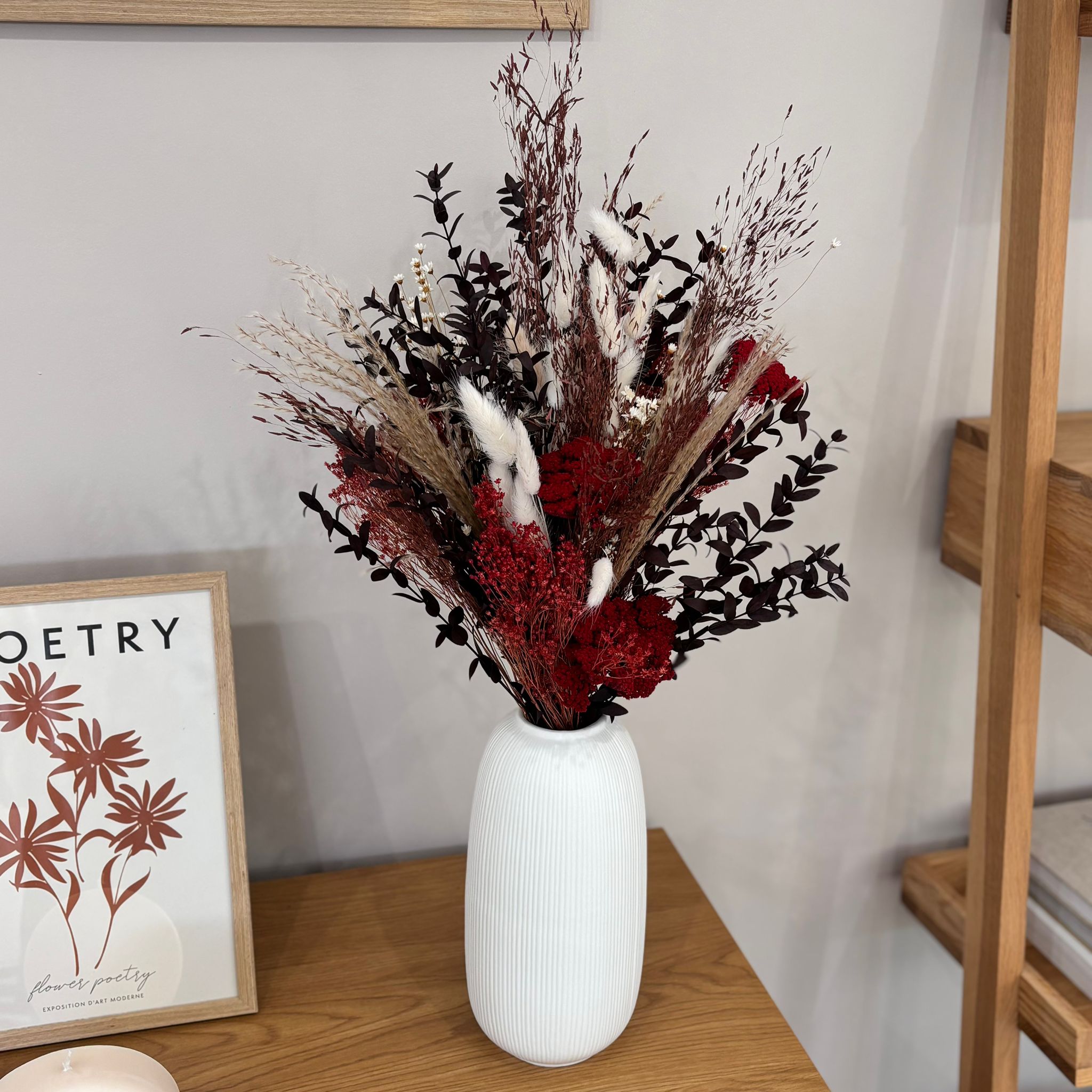 Dried flower bouquet featuring purple blooms and eucalyptus in a modern gray vase. Perfect for home decor.